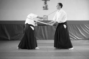 Aikido training full of fun; sensei demonstraing common mistakes in his student technique
