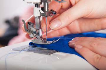 Woman threading on sewing machine - obrazy, fototapety, plakaty