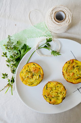 Savoury cheese muffins with fresh herbs on white plate