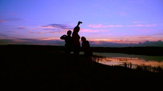 Children with mother make selfie phone at sunset