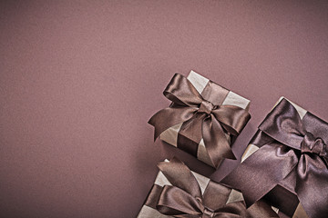 Composition of wrapped giftboxes on brown surface holidays conce