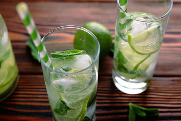 lemonade with lime and ice on a wooden background