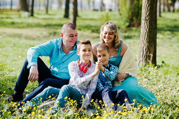 Happy pregnant family with two sons, dressed in a turquoise clot