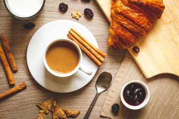 Breakfast with coffee and croissants on wooden table