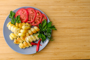 Tomatoes and potatoes. Spice. On a plate of ceramics. Rustic.