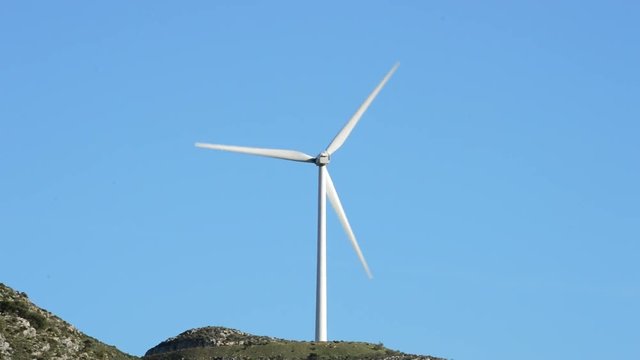 Wind turbine energy rotating at sunny day with blue sky