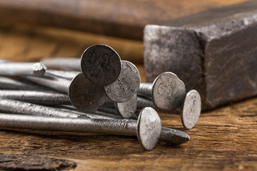 Vintage hammer with nails on wood background