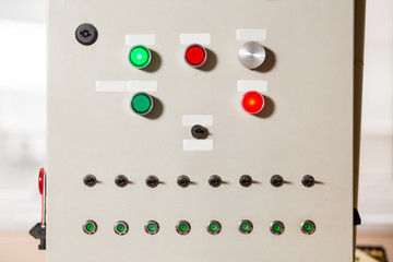 Buttons and switches on panel. Gray panel with colorful buttons. Conveyor's control panel. Device for coordinating machinery's work.