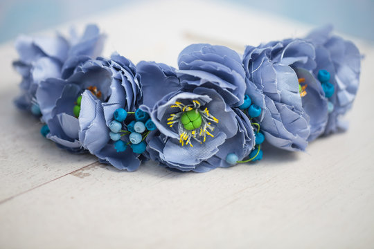 Diadem of blue flowers on white wooden surface