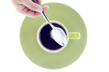 close-up shot of a person putting sugar in black coffee.