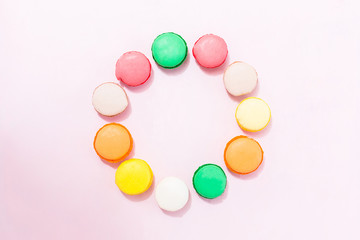 Sweet colorful French macaroon biscuits on pastel background, to