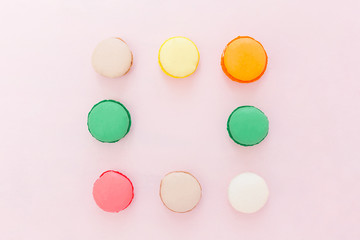 Sweet colorful French macaroon biscuits on pastel background, to