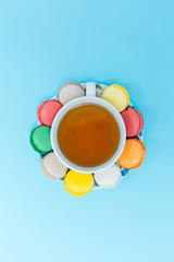 Colorful macaroons with cup of tea