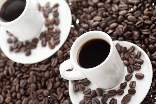 close-up image of two black coffee cups.