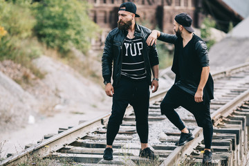 Fototapeta premium Two bearded men posing on a industrial zone