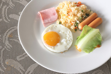 Breakfast with fried rice and fried egg in a white dish.