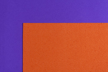 Fototapeta premium Eva foam ethylene vinyl acetate sponge plush orange surface on purple smooth background