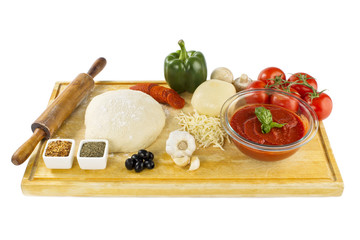 pizza ingredients on wooden plank.