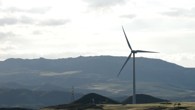 Wind turbine energy moving in the mountain at cloudy day