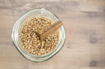 Lentils in glass bowl and wooden spoon