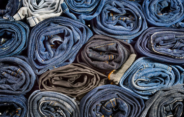 Lot of different blue jeans close-up, background