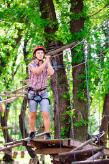 Naklejka na ściany i meble adventure climbing high wire park - people on course in mountain