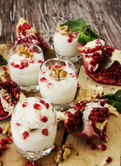 yogurt dessert with walnuts and pomegranate selective focus