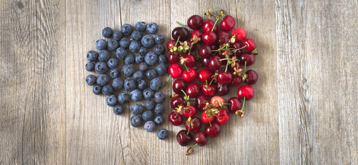 Heart of berries on a wooden table in natural light