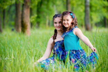 Two sisters lying on the grass and cute smile