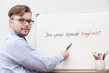 Young caucasian teacher pointing on title Do you speak english