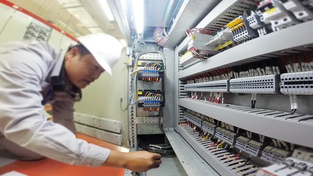 Electrician to check electrical circuit in control panel , substation room of industrial plant