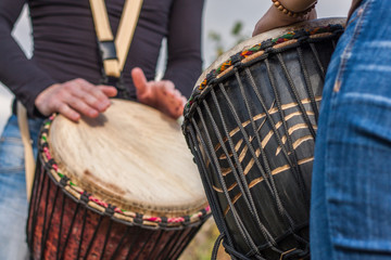 Fototapeta na wymiar People hands playing music at djembe drums