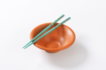 Blue chopsticks on a bowl