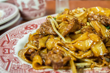 Closeup of beef and chow fun noodles at Chinese restaurant.  Shallow depth of field photo.