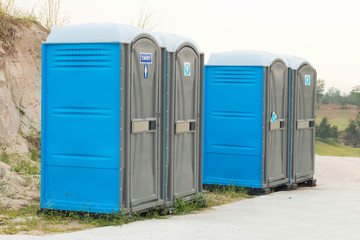 Two blue portable toilet cabins at construction site