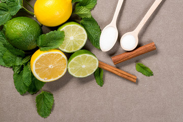Yellow lemon, lime and green mint leaves on  wooden background. Top view