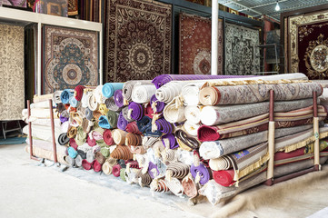 Heap of rolled up rugs in rug store