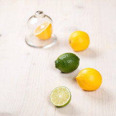 Yellow lemon, lime and green mint leaves on  wooden background. 