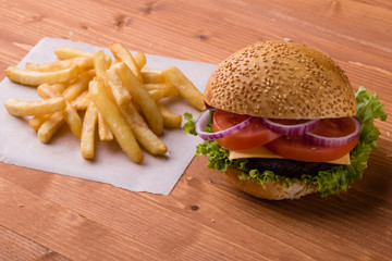 homemade hamburger on wooden table with fries