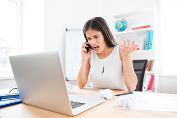 Angry businesswoman talking on the phone