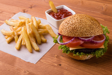 homemade hamburger on wooden table with fries