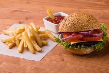 homemade hamburger on wooden table with fries