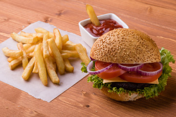 homemade hamburger on wooden table with fries