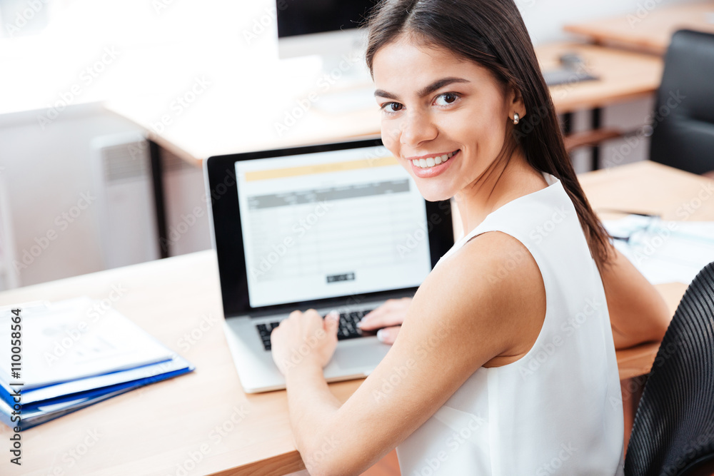 Wall mural Businesswoman using laptop computer in office