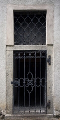 Historical house door. Big metallic old door. One timber leaf, closed black gateway with metal and...