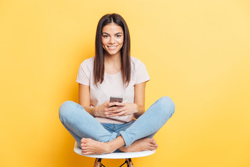 Woman sitting on the chair and using smartphone