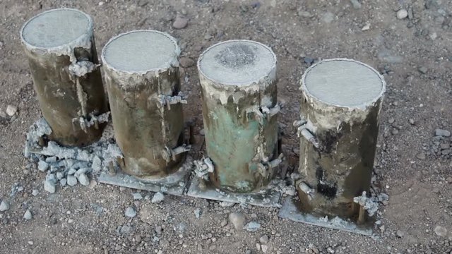 Handheld shot of concrete sample cylinders that are used to test for quality and engineering strength or used as proof of the materials on a construction job.
