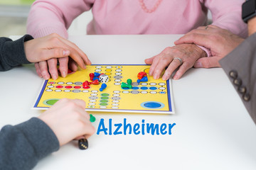 familie spielt mit alzheimer erkrankten seniorin