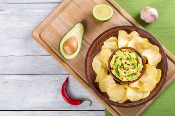 bowl of guacamole dip and potato chips