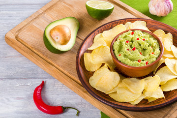 bowl of guacamole dip and potato chips